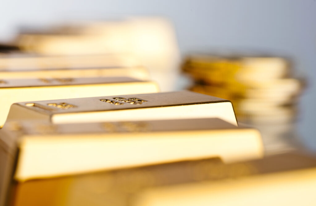 Blurred close-up of gold bars stacked in a row, evoking wealth and precious metal storage.