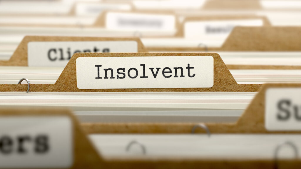 Close-up of a filing-tab with the label 'Insolvent' among blurry neighboring tabs.